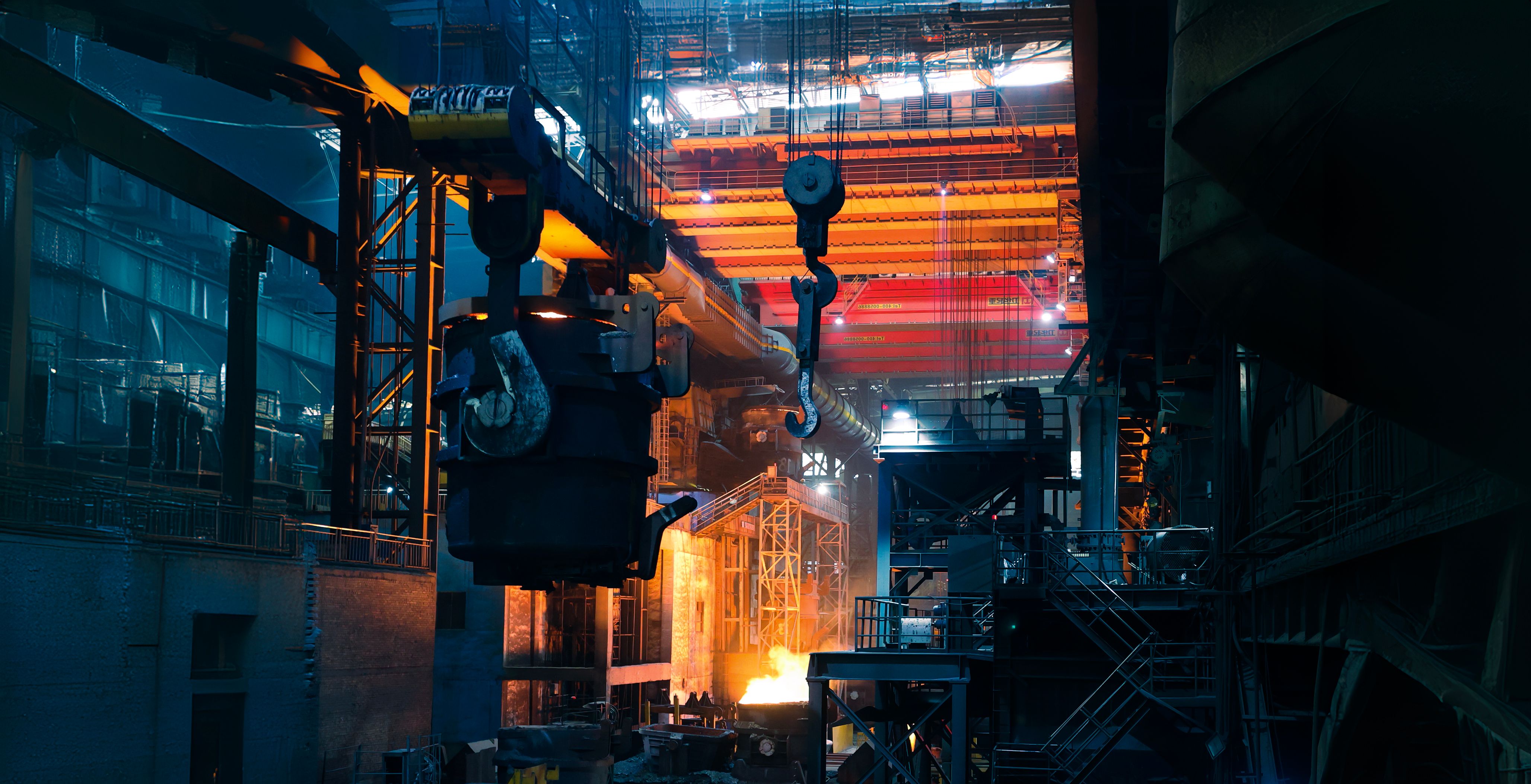 Industrial materials processing facility with overhead cranes and molten metal